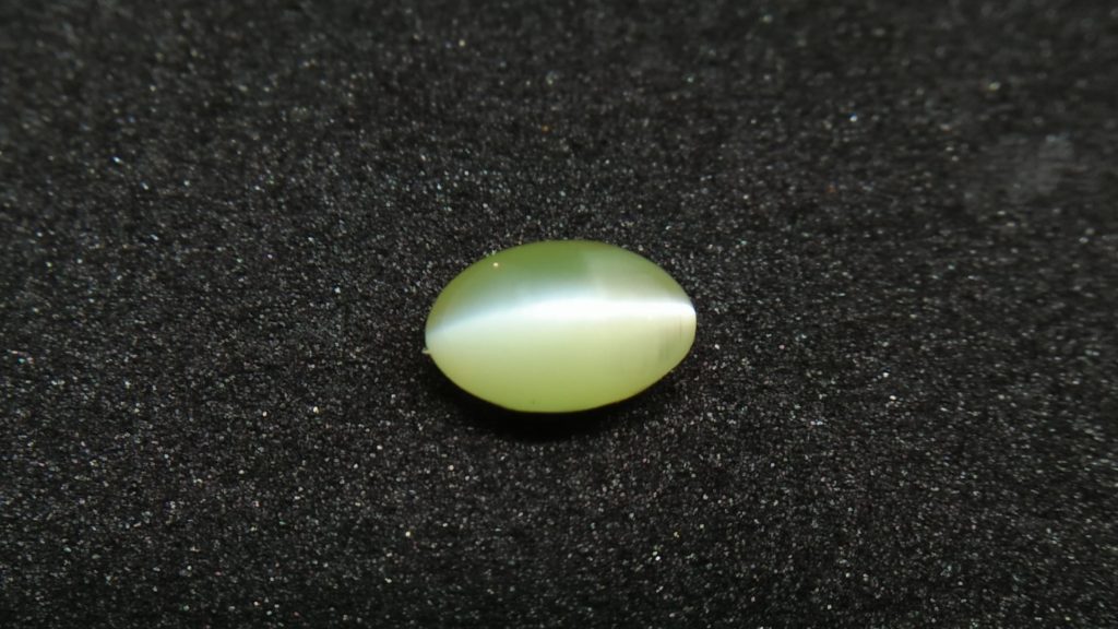 Chrysoberyl Cats Eye Colour : Greenish Yellow Shape : Oval Cut : Cabochon Weight : 1.04 Cts Dimension : 6.5 x 4.1 x 4.1 mm Treatment : Unheated Clarity : Clean • CSL - Colored Stone Laboratory Certified ( GIA Alumina Association Member ) • CSL Memo No : 96FCB5F4103D V The Gemstone Chrysoberyl is an aluminate of beryllium with the chemical formula BeAl₂O₄. The name chrysoberyl is derived from the Greek words "chrysos" and "beryllos". Its meaning is "a gold-white spar". It is known as a hard and durable gem after Sapphire. Chrysoberyl is an orthorhombic crystal mineral with 3.5 – 3.84 specific gravity and 8.5 hardness according to the more hardness scale. It is a Biaxial (+) mineral with refractive indexes nα=1.745 nβ=1.748 nγ=1.754. Chrysoberyl family Gemstones from old collection Chrysoberyl can be found colors such as green, yellow, brownish to greenish-black, colorless, pale shades of yellow, greenish Yellow, Yellowish Green, Honey Brown, Reddish Brown, Orangy yellow, Greenish Brown, Blue. Also, Golden Yellow Chrysoberyl is called "Ceylonese Chrysolite" as a trading name. Alexandrite Alexandrite cats eye The Chrysoberyl Alexandrite is a color change variety upon the nature of ambient lighting. It changes the color green to brownish red or green to purplish-red in the incandescent light from a lamp or candle flame. However, Alexandrite's good color change stones are extremely rare. also, Chrysoberyl alexandrite can be found with a chatoyancy future. It is rare and expensive. Chrysoberyl crystal from Danu Group Old Collection An interesting feature of its crystals are the cyclic twins called trillings. Alexandrite Crystal Under UV Also, Chrysoberyl can be found with the chatoyancy feature. Translucent yellowish chatoyant chrysoberyl is called as cymophane. Also, Chrysoberyl cat's eye is found in colors such as yellowish-green, green, honey brown, grey. The chrysoberyl gemstone or mineral can be found in Sri Lanka, Afghanistan, India, Madagascar, Tanzania, Ethiopia, Australia, Brazil, Canada, France, Germany, Italy, Japan, Kenya, Kazakhstan, Namibia, Myanmar, Mozambique, Norway, Russia, Spain, USA, Zambia. Healing Properties of Chrysoberyls Chrysoberyl is known as an effective and protective stone since ancient times. It transforms negative thoughts into positive energy. Chrysoberyl gemstone or mineral is associated with wealth and creativity and promotes tolerance and harmony. It stimulates the solar plexus and crown chakras. Chrysoberyl helps to open the crown chakra and increases both spiritual and personal power. Green chrysoberyl stimulates the healing of the physical heart. Chrysoberyl stimulates the cleansing and balancing of the liver, kidneys, gall bladder and balances adrenaline and cholesterol and fortifies the chest and liver. Chrysoberyl Cat's eye increases the vibration of Ketu in the wearer according to Vedic Astrology. It is known to reduce the malefic effects of 'Ketu' and increase its beneficial qualities. Chrysoberyl transforms negative thoughts into positive energy. It supports self-healing. Chrysoberyl balances adrenaline and cholesterol and fortifies the chest and liver.