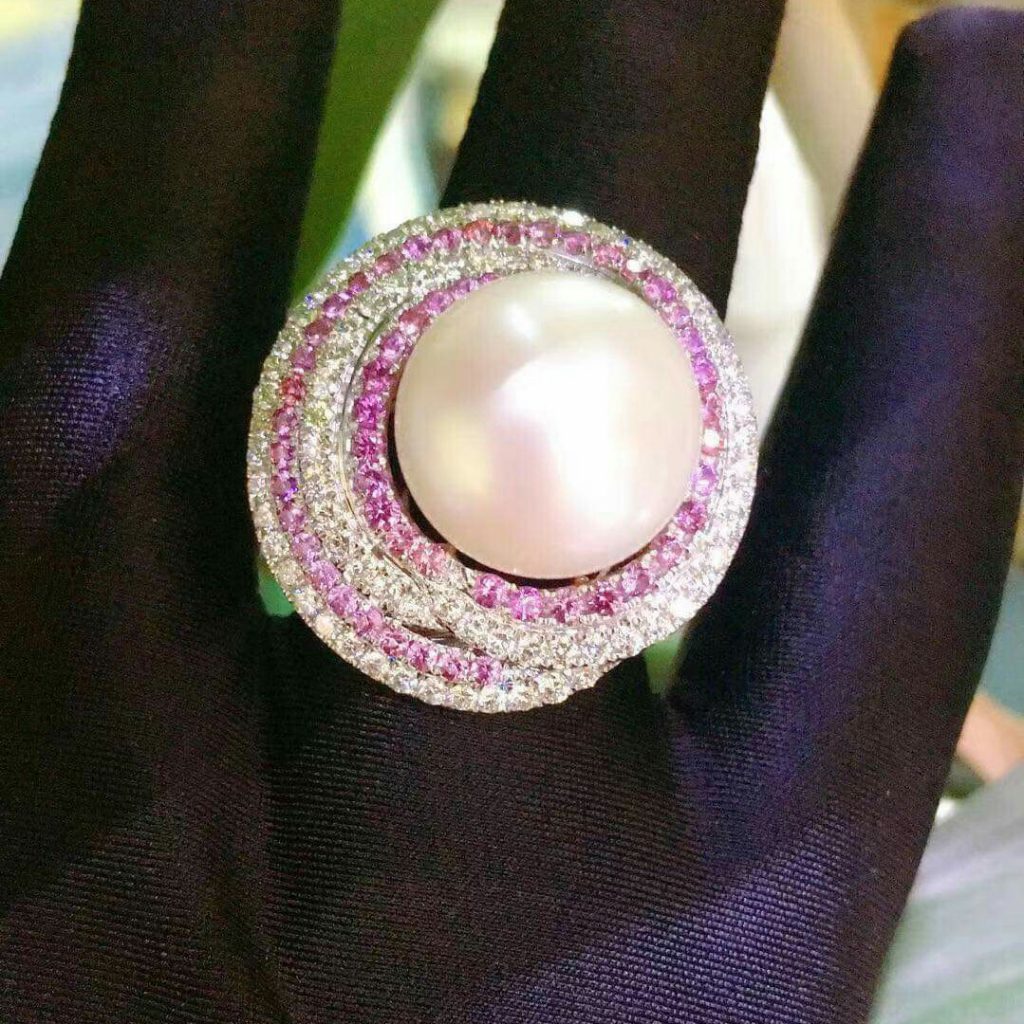 Natural Pearl, Pink Sapphire & Diamond 18K White Gold Ring - High Quality ( Made in Japan ) Pearl : 20ct /20 mm 18K white gold : 12.95 g Natural Pink sapphire: 58 pcs (1 ct) White diamond : 106 pcs (over 2 cts) Design by : SUI SUI Natural Pearl, Pink Sapphire & Diamond 18K White Gold Ring - High Quality ( Made in Japan ) Pearl is composed of calcium carbonate " CaCO3 " in minute crystalline form, which has been deposited in concentric layers. Healing Properties of Pearl Pearl is beneficial for lung diseases such as tuberculosis, asthma, chronic bronchitis. It facilitates the healing of the heart, kidneys, urinary system and liver. Pearl possesses a sedative and also laxative effect, neutralizes poison, lowers acidity