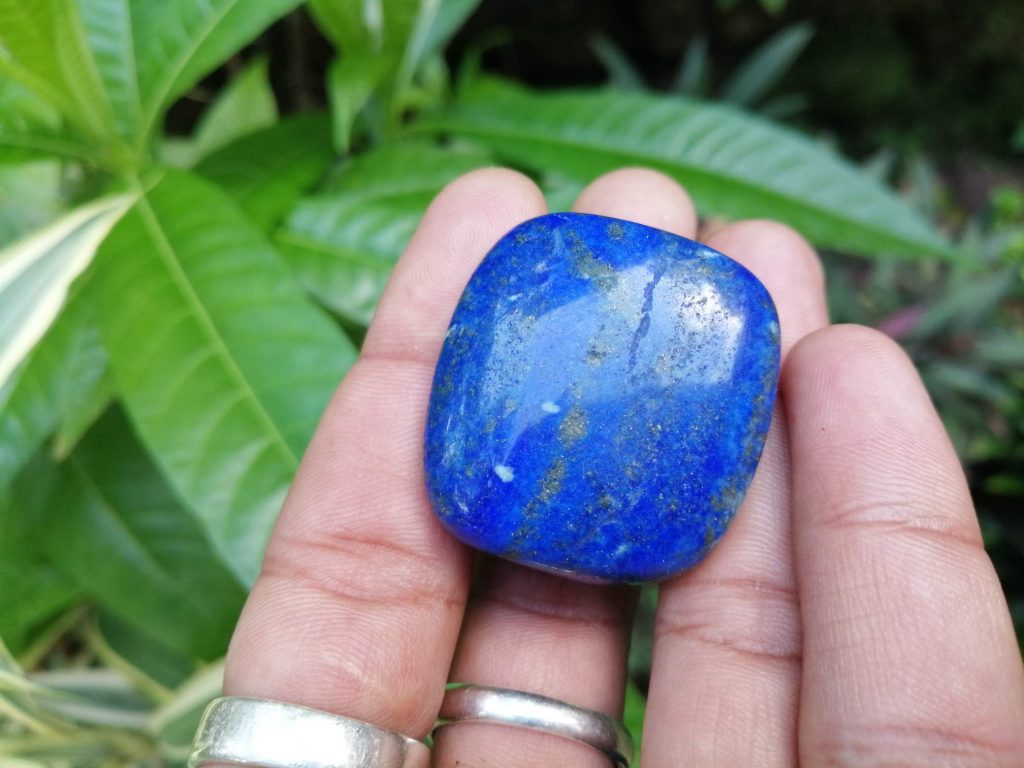 Lapis lazuli is a deep blue metamorphic ( arise from the transformation of existing rock types) rock used as a semi-precious stone, a mixture of minerals with lazurite as the main constituent. Lazurite is a tectosilicate mineral with sulfate, sulfur, and chloride. Lapis lazuli can be found colors such as Blue, or purple, mottled with white calcite and brassy pyrite. As Physical Properties, It has Uneven and Conchoidal fractures and a dull luster. Lapis Lazuli specific gravity is 2.7–2.9 with 5–5.5 hardness according to the Mohs hardness scale. The refractive index is Refractive Index1.500 to 1.670 as optical properties. The variations in composition cause a wide variation in the specific gravity, Refractive index and hardness values. At the end of the Middle Ages, lapis lazuli began to be exported to Europe, where it was ground into a powder and made into ultramarine, the finest and most expensive of all blue pigments. In ancient Egypt, lapis lazuli was a favorite stone for amulets and ornaments such as scarabs. Lapis lazuli is found in Afghanistan, Russia, Chile, Italy, Mongolia, Pakistan, the United States, and Canada. Afghanistan is the major source of lapis lazuli. Healing properties of Lapis lazuli 💎 Lapis lazuli associates with Throat Chakra and Third Eye Chakra. Lapis Lazuli activates the psychic centers at the Third Eye and balances the energies of the Throat Chakra. Also, Lapis lazuli is the September birthstone. Lapis Lazuli releases stress, bringing peace, harmony, and inner self-knowledge.  Lapis Lazuli boosts the immune system, purifies the blood and lowers blood pressure. Lapis is one of the oldest spiritual stones known to man, used by healers, priests and royalty, for power, wisdom and to stimulate psychic abilities and inner vision.