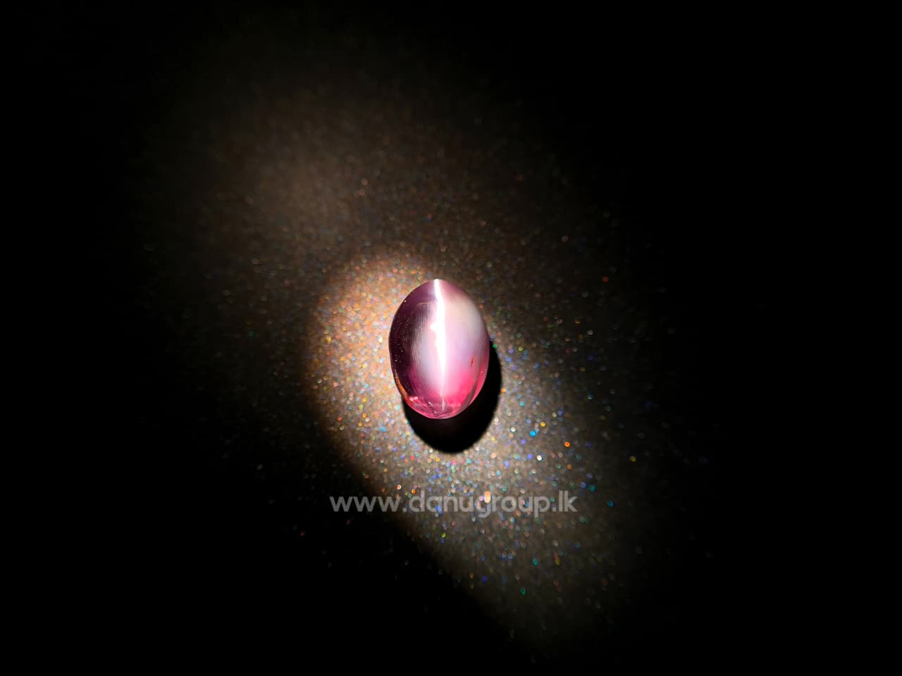 Two Alexandrite Cat’s Eye gemstones on white background showing green and red color-change appearances with visible cat’s eye effect.