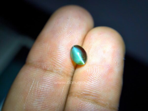 Natural Alexandrite Cat’s Eye gemstone with red color-change appearance and distinct eye effect on dark background.