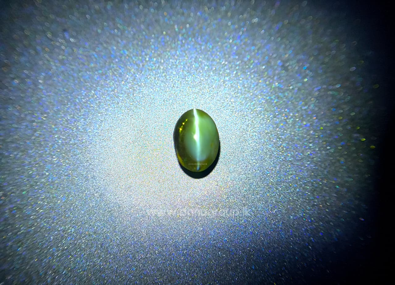 Oval red color-change Alexandrite Cat’s Eye gemstone with centered eye effect on dark background.
